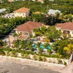 Aerial view of the walled two-villa compound with the shared pool and tropical gardens between the houses