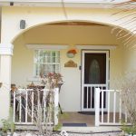 Sea Villa's arched front porch, with white railings and the front door